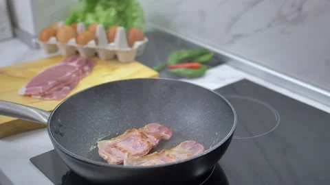Frying bacon in a pan Stock Footage 142135485