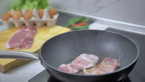 Frying bacon in a pan Stock Footage 142135543