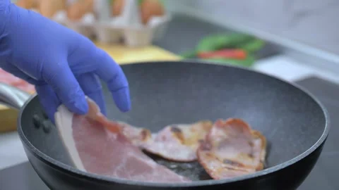 Frying bacon in a pan Stock Footage 142135628