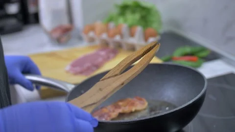 Frying bacon in a pan Stock Footage 142135658