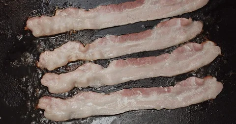 Frying Bacon on Skillet or Pan Aerial View Slow Motion Stock Footage 106965332