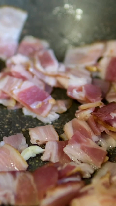Frying bacon slices in pan, close up. Crispy pieces of delicious Bacon Fried in 動画素材 303490299