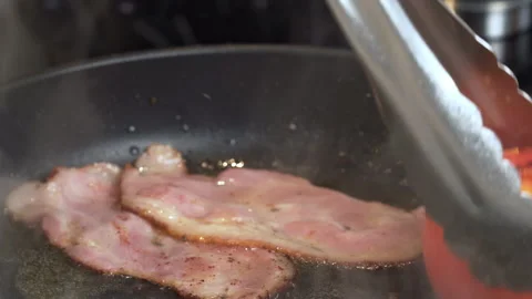 Frying Bacon Slices in a Pan. Crispy Pieces of Delicious Red Thin Smokey Bacon. Stock Footage 240706162