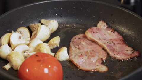 Frying Bacon Slices in a Pan. Crispy Pieces of Delicious Red Thin Smokey Bacon. Video stock 241145730