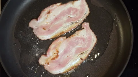 Frying Bacon Slices in a Pan. Crispy Pieces of Delicious Red Thin Smokey Bacon. Stock Footage 246009256