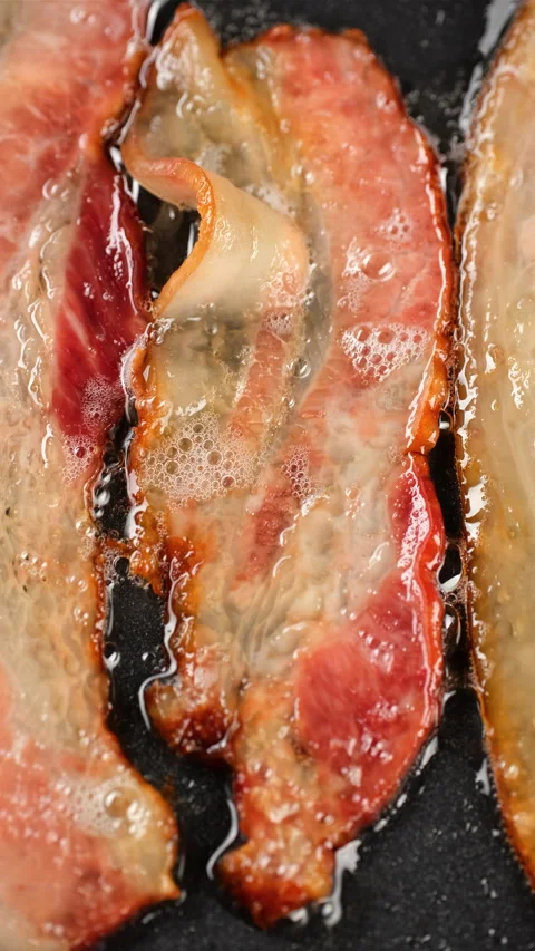 Frying bacon slices in pan. Vertical video Video stock 270122742