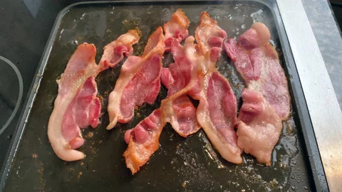 Frying bacon on a stovetop Stock Footage 166592232