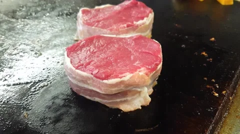 Frying bacon wrapped, filet mignon tournedos steaks, at a restaurant kitchens Stock Footage 63010753