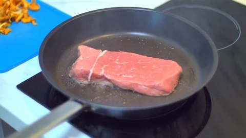 Frying beef steak in a pan Stock Footage 114077289