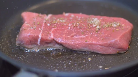 Frying beef steak in a pan Stock Footage 114079284