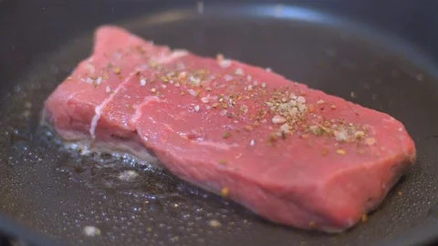 Frying beef steak in a pan Stock Footage 114079502