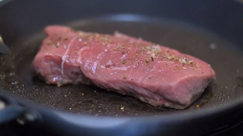 Frying beef steak in a pan Stock Footage 114079920