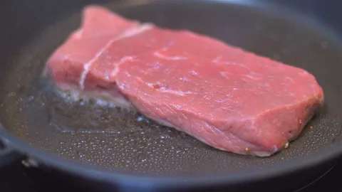 Frying beef steak in a pan Stock Footage 114080387