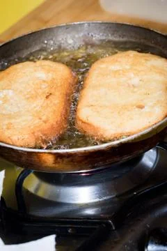 Frying bread to make a typical Spanish food, torrijas. Stock Photos