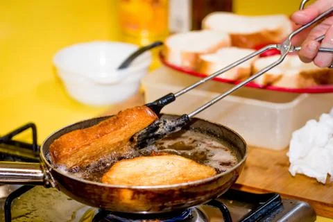 Frying bread to make a typical Spanish food, torrijas. Stock Photos
