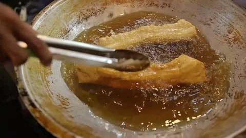 Frying cakwe while turning around Stock Footage 270347187