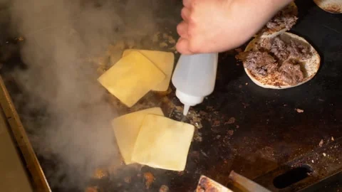 Frying cheese for a sandwich on large grill in restaurant kitchen 4K 60fps Stock Footage 196988664