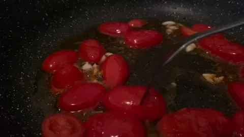 Frying cherry tomatoes with garlic Stock Footage 224718994