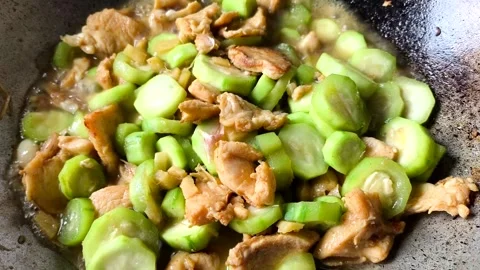 Frying  chicken breast with angled squash in pan, indoor Chiangmai Thailand. Stock Footage 312903300