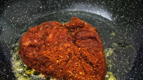 Frying chicken breast covered in cajun spices seasoning slowmotion Stock Footage 247644100