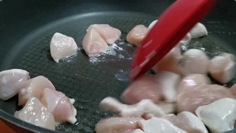 Frying Chicken Breast Cubes in a Frying Pan Stock Footage 234882889