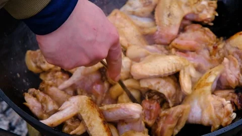 Frying chicken in a cauldron. Chicken meat in a cauldron. Outdoor cooking Stock Footage 279271641