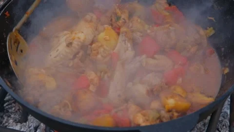 Frying chicken in a cauldron. Chicken meat in a cauldron. Outdoor cooking Stock Footage 280354923