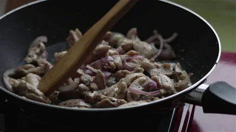 Frying chicken meat and red onion in pan close up Stock Footage 237368202