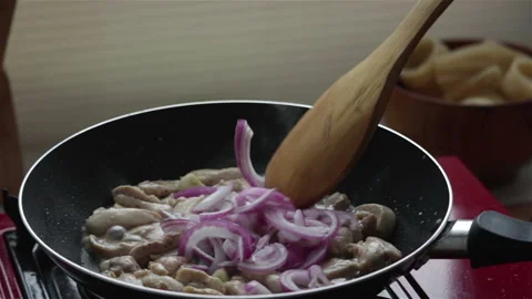 Frying chicken meat with red onion in pan close up Stock Footage 147192858