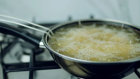 Frying Chicken in a pan full of oil. A pan with a frying basket in 4K. Stock Footage 138281861