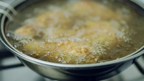 Frying Chicken in a pan full of oil. A pan with a frying basket in 4K. Stock Footage 138282895