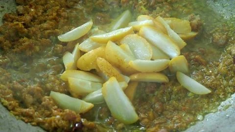 Frying chili paste with chopped fresh dates in pan, in door  Chiangmai  Thailand Stock Footage 202560522