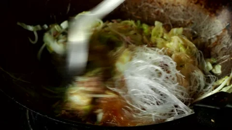 Frying chopped cabbage with vermicelli in pan , in door  Chiangmai  Thailand Stock Footage 263001020