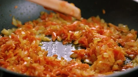 Frying chopped onion and carrot on the frying pan Stock-Footage 149573534