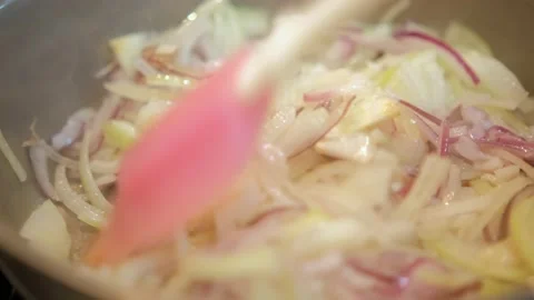 Frying chopped onion in frying pan. Slow motion. Chef pouring down pieces of Stock Footage 221814188