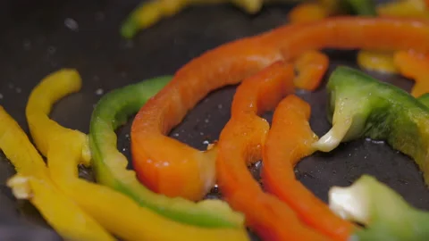 Frying chopped red, green, yellow bell pepper on fry pan slow motion 4k Stock Footage 149689405