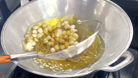 Frying cimol (fried tapioca balls) video in hot oil in a wok Stock Footage 321554411