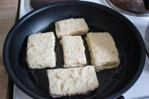 Frying coated cheese Eidam in breadcrumbs Stock Photos