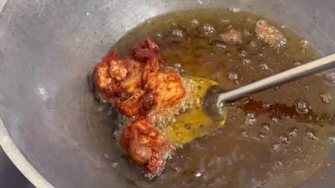 Frying crispy fried chicken in hot oil in a wok Stock Footage 340485787