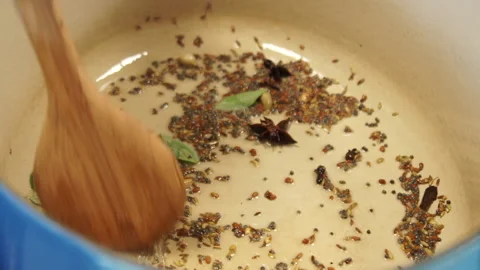 Frying curry spice's then adding curry leaves and onion. Stock-Footage 136021975