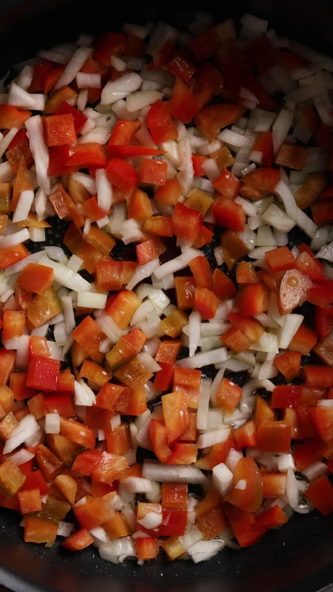 Frying Diced Onion and Red Bell Pepper in Pan Close Up Vertical Top View Vidéo 336571599
