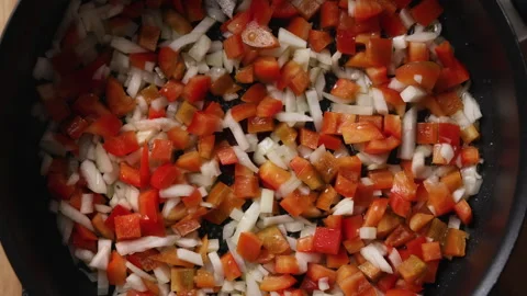 Frying Diced Onion and Red Bell Pepper in Pan Close Up Top View Vidéo 336571602