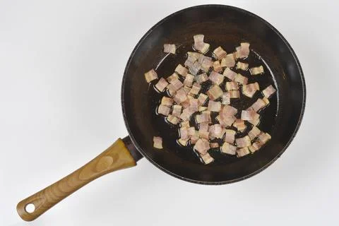 Frying diced pancetta cubes in a pan isolated on white background Stock Photos