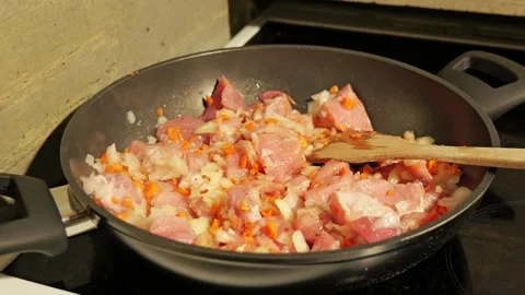 Frying diced pork with onions and carrots in a pan 스톡 동영상 342758712