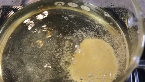 Frying donut, preparing donut at home, slow motion, glass pot Stock Footage 204999573
