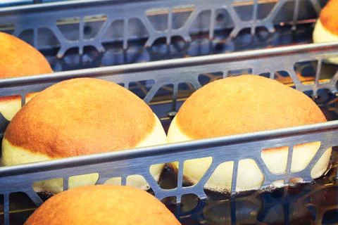 Frying donuts in oiled pans. Stock-Fotos