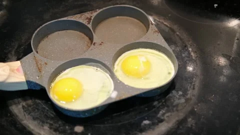 Frying an egg in a 4 circle pan Stock Footage 334244654
