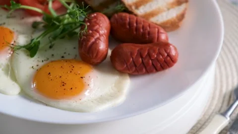 Frying Egg and Sausage Breakfast Closeup Video Vídeos de archivo 332110084