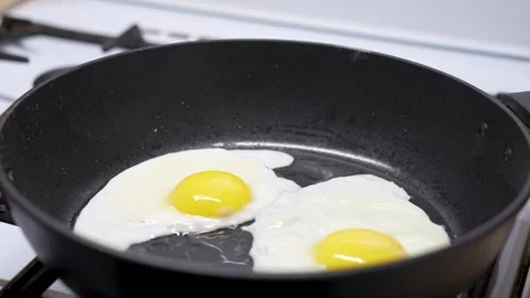 Frying Egg in a Cooking Pan, close-up. Cooking healthy breakfast Stock Footage 272156142