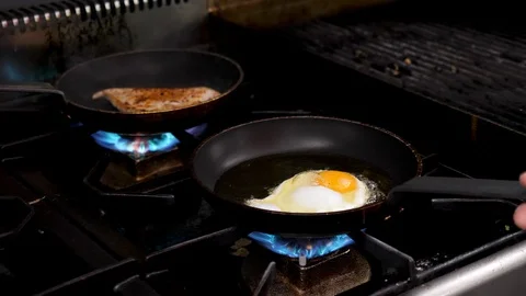 Frying egg in the kitchen on a pan Stock Footage 95948870